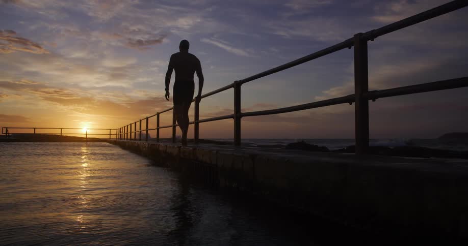 Man walking on a cement crack by the sea