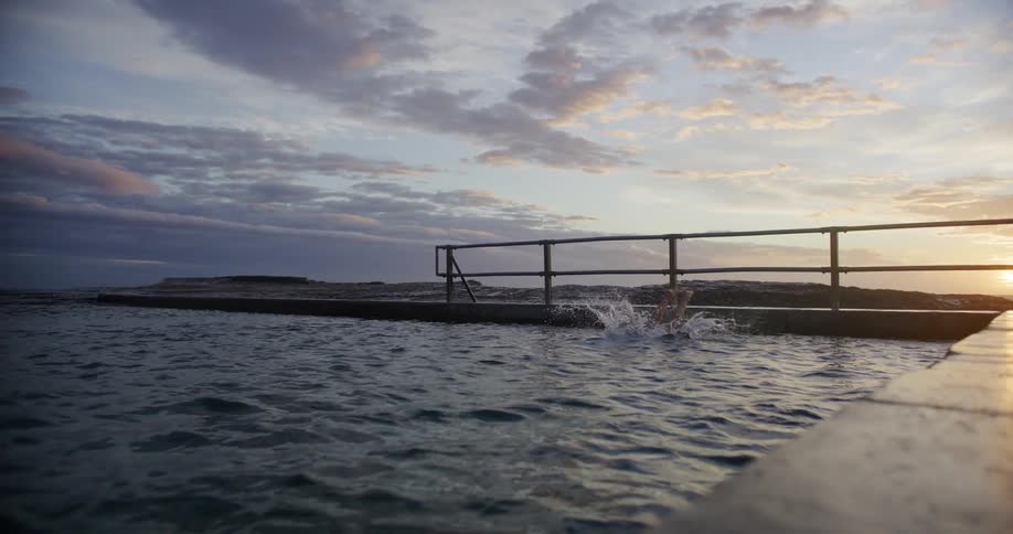 Person diving into a water tank to swim