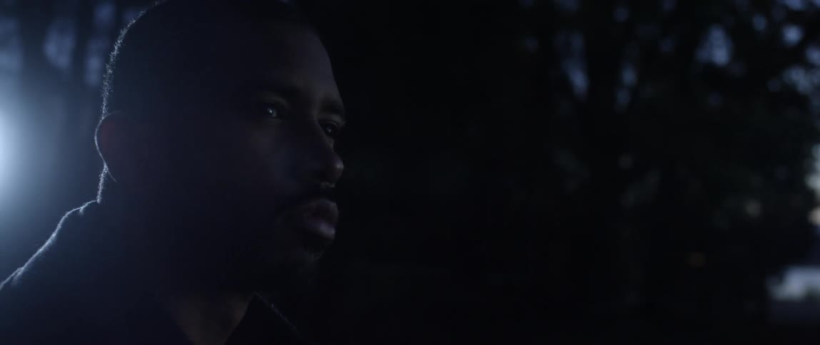 A man gazing around in a wooded area next to a body of water
