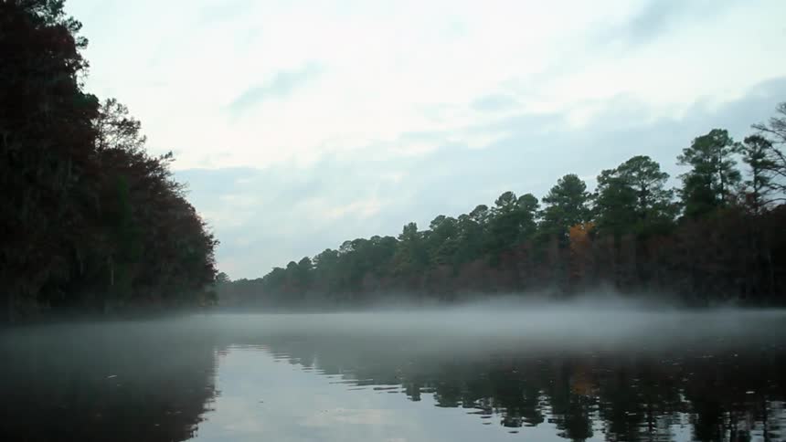 A foggy lake being filmed early in the morning