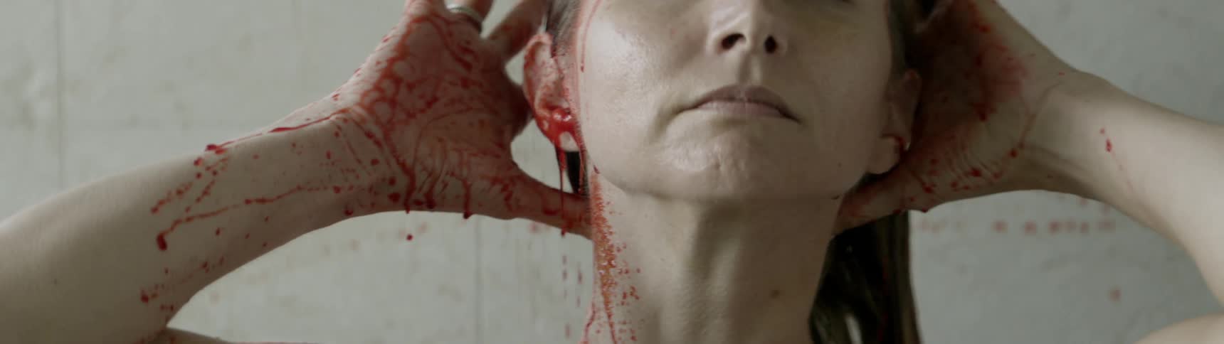 A woman washes blood off of her head
