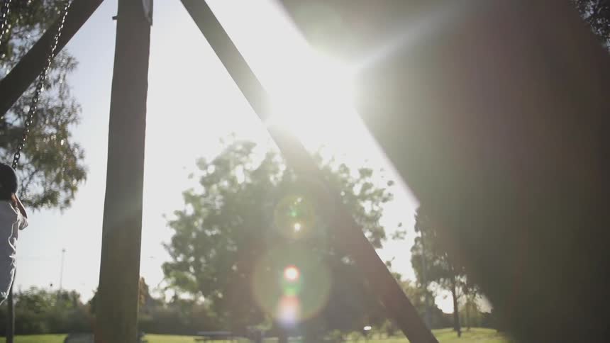 A child plays on a swing set