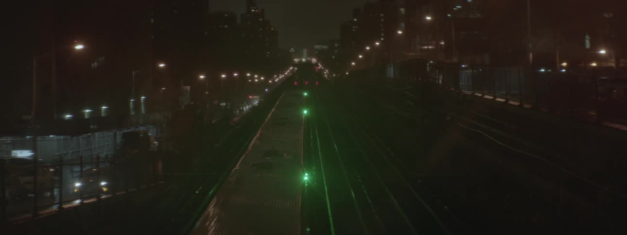 A train is pulling into a station on a foggy night
