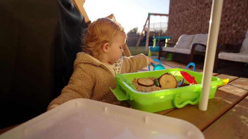 A child is playing with sand at the playground