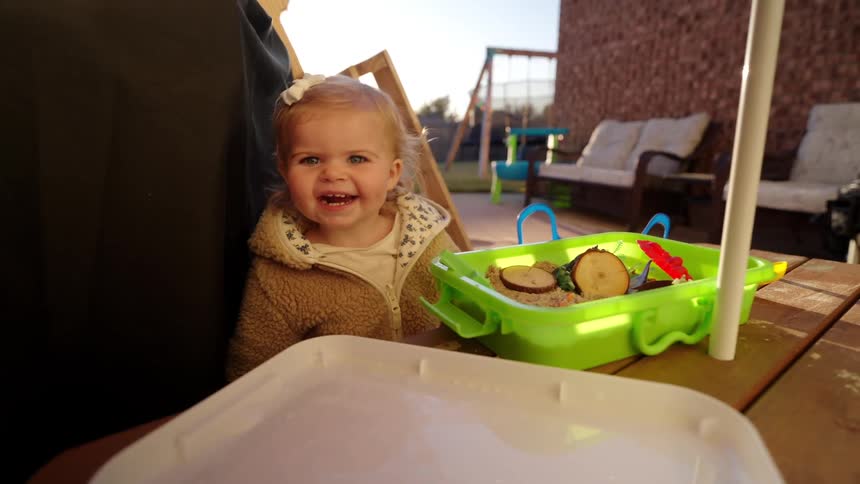 Little blonde girl sitting on chair smiling