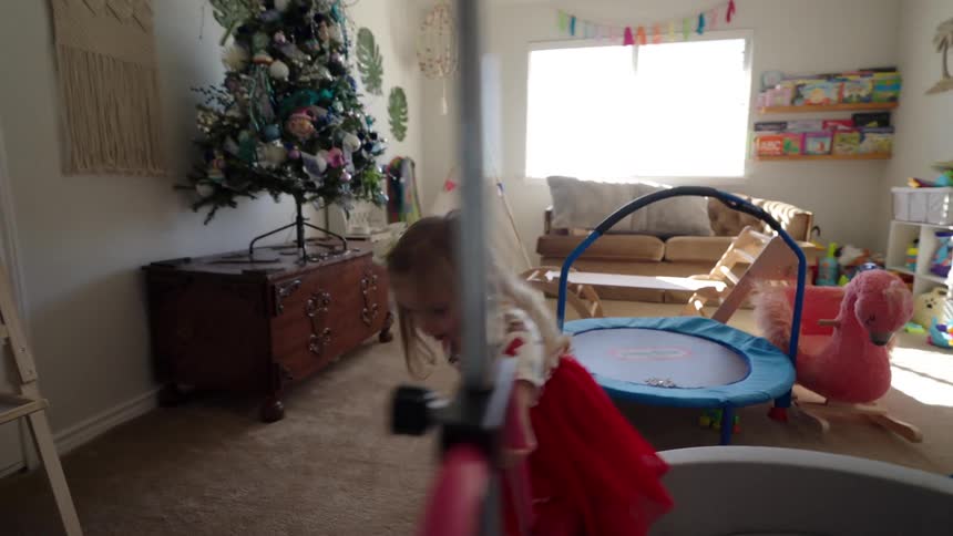 Girls play and run around in a colorful bedroom filled with toys
