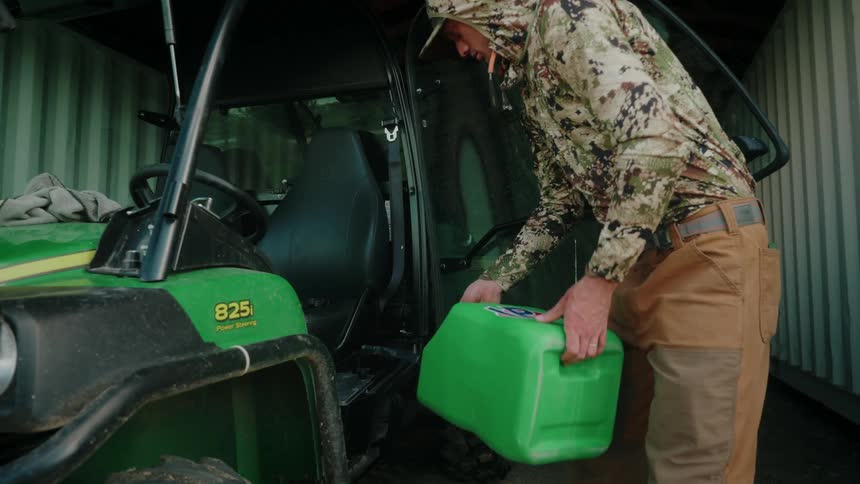 A rancher fills a John Deere quad up with fuel