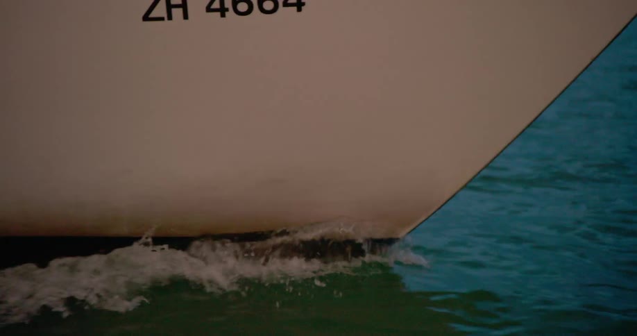The image shows the bow of a boat cutting through the water