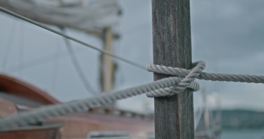 A clip of a person tying a rope to a wooden pole