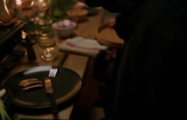 People sharing a festive feast surrounded by flickering candles