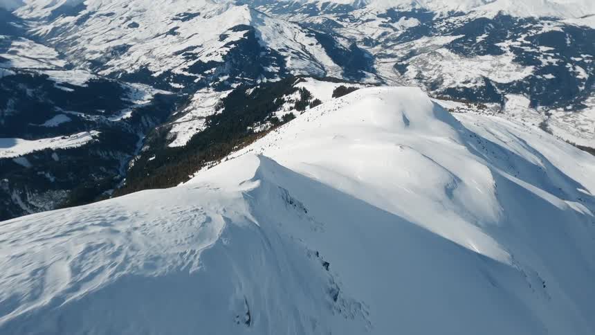 A panoramic vista of a snowcovered peak revealing a sprawling mountain range blanketed in snow