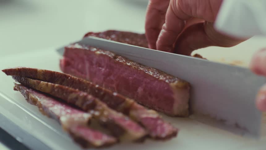 Knife cutting slices of meat