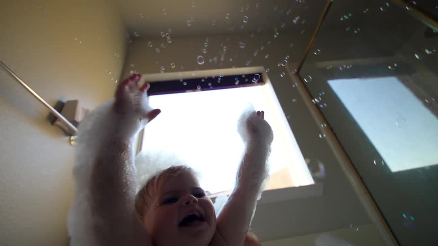 Girls taking a bath playing with soap bubbles in the tub
