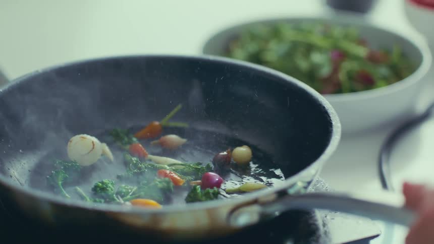 Small vegetables being sauted in a skillet