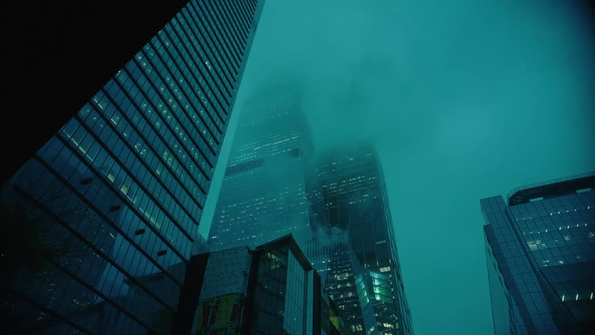 Upward view of modern urban buildings against a cloudy sky