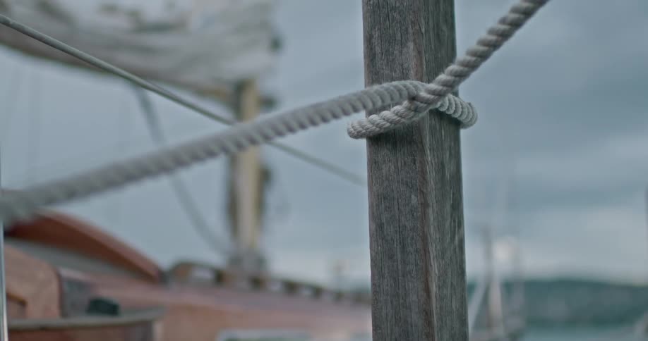 Hand placing a rope on a wooden support