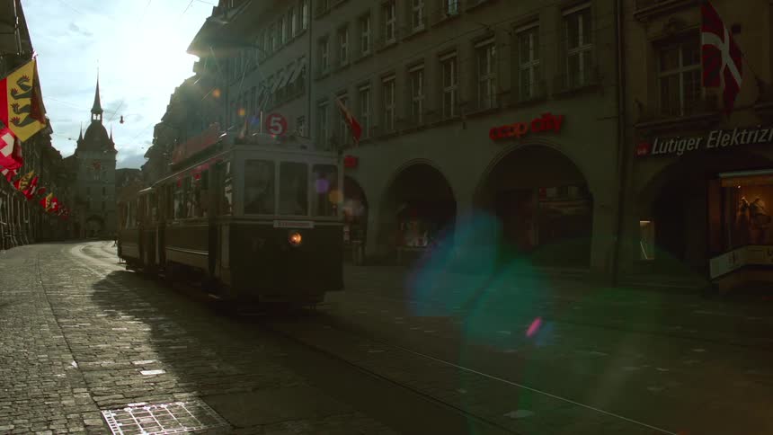 Tram passing through the middle of a classic city with a cathedral in the background