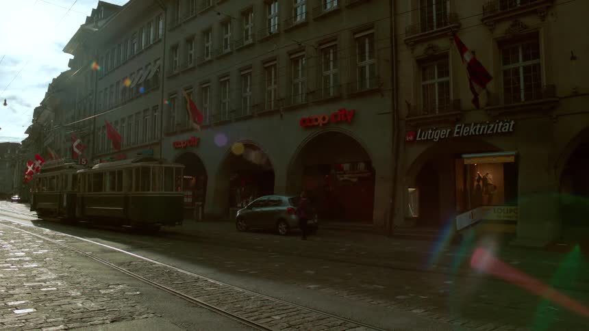 A trolley train drives past all the storefronts