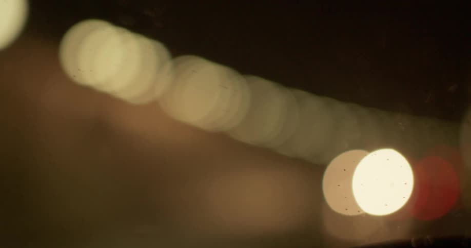 Blurry headlightsmove in the opposite direction of a vehicle at night