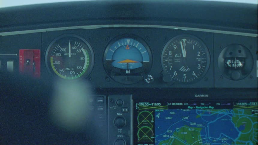 Hands of two people pointing at information on an airplane cockpit panel