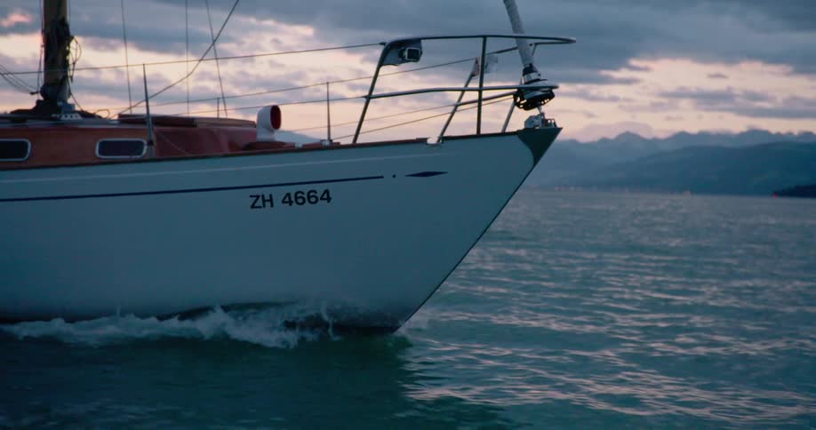 Boat sailing on the water off the coast under a cloudy sky
