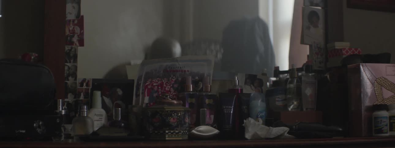 A man sits in front of a vanity then gets up and leaves