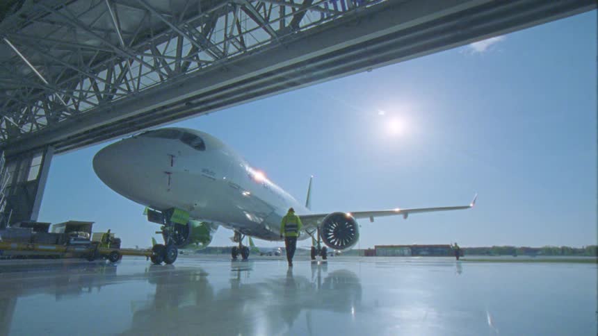 Plane leaving the parking lot with people helping