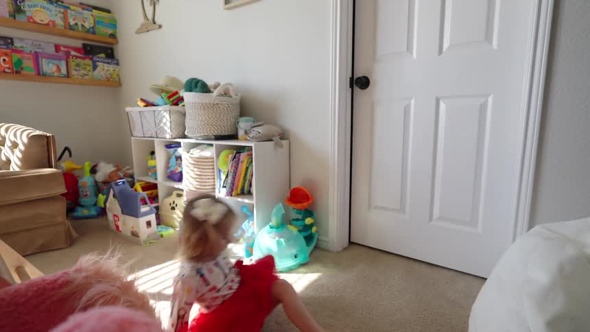 Little girl twirling around fast then falling on the ground in her bedroom