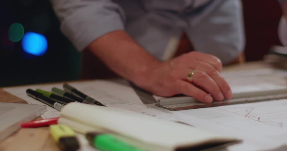 Hands holding a ruler and pencil taking measurements on a project
