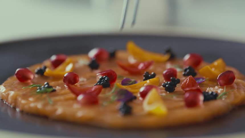 A thin tool for placing a small ingredient into a doughlike food that is on a metal surface