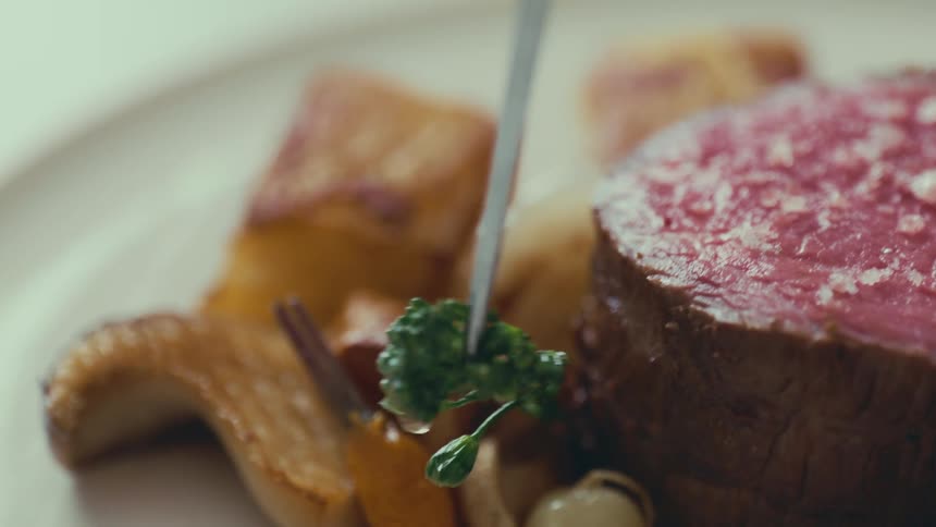 A gourmet meal with a perfectly seared steak roasted potatoes and other vegetables on a plate