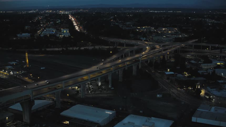 An aerial view of a city at night with illuminated roads and buildings forming a gridlike pattern