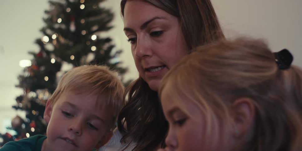 A mother is sitting and reading to her children