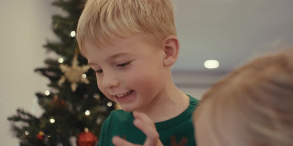 Children are talking to each other by the christmas tree