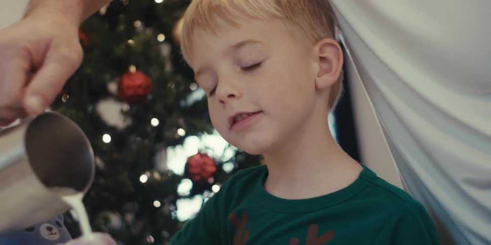 Milk foam is pouring into a mug for the child
