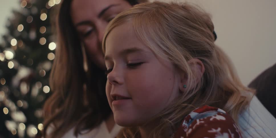Mother and daughter hugging each other and sitting on the sofa in the living room