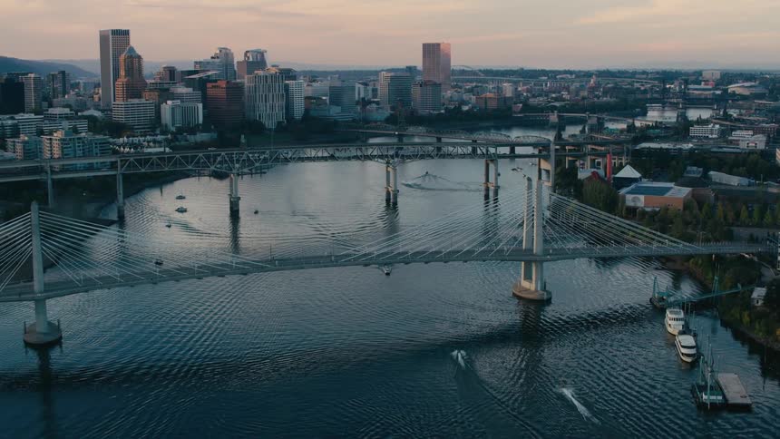 Several suspension bridges that pass over a large water channel in the middle of a metropolitan city
