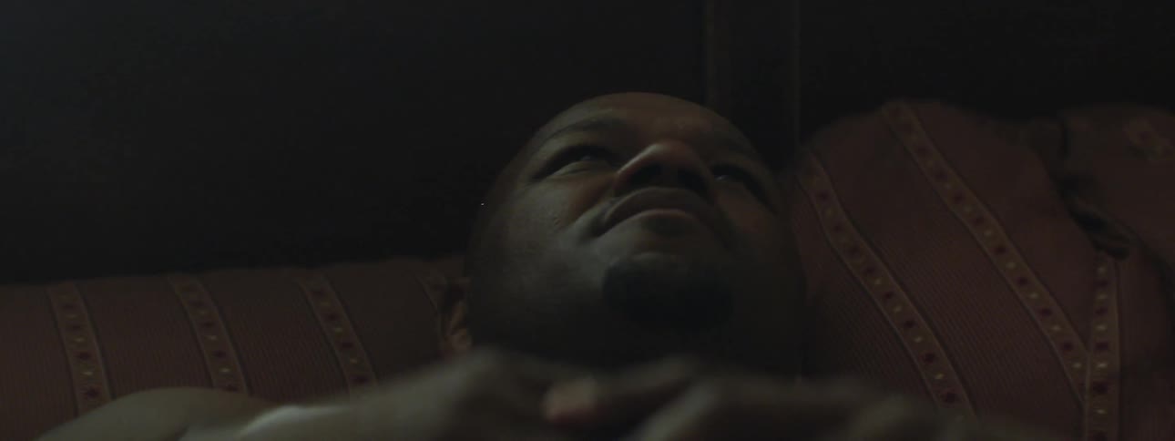A man lays on a pillow with his eyes open