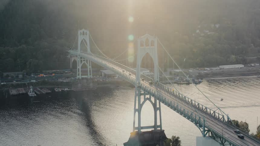 A huge suspension bridge over a body of water with several cars passing over it