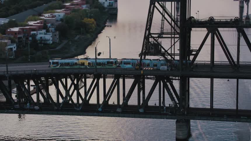Train crossing a bridge above a sea canal