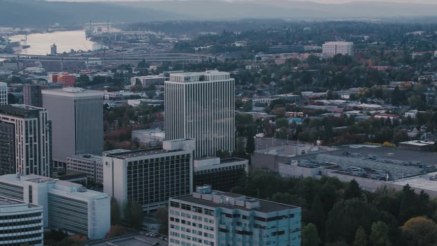 An aerial view of portland oregon showcasing a dense urban landscape with highrise buildings and a network of highways weaving through the city