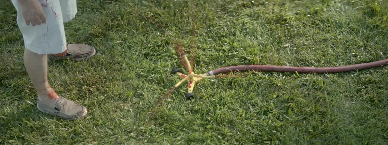 A sprinkler is spraying red liquid in a circle