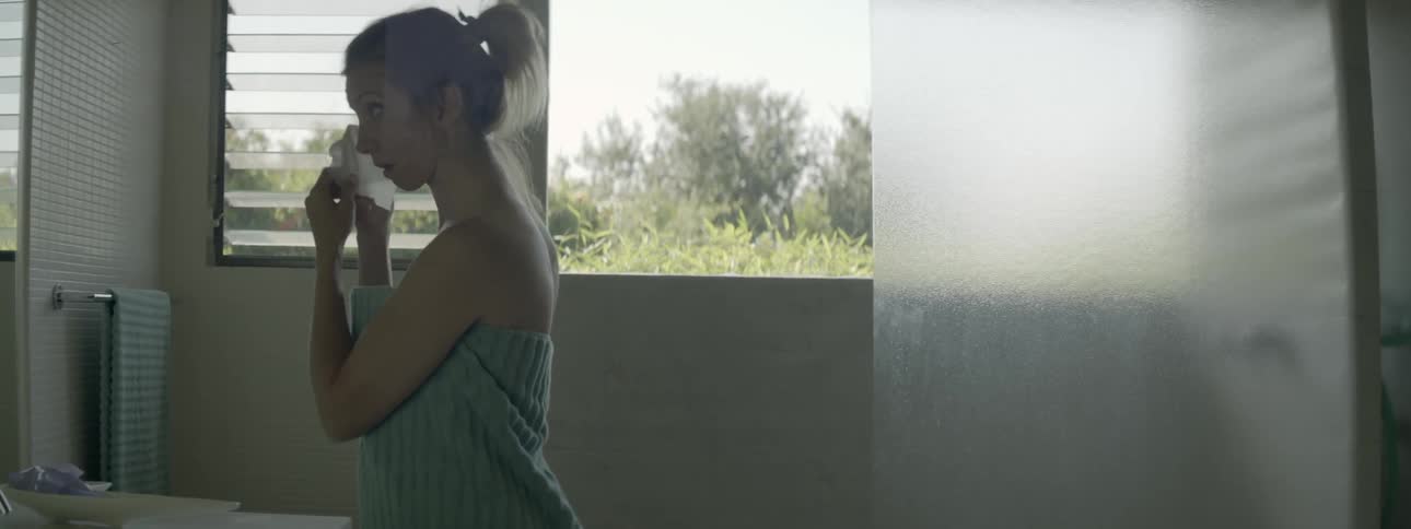 A woman is wiping her face with a cloth