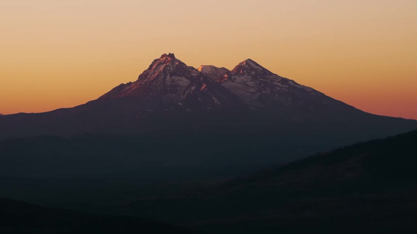 Snow on the mountain range under a sunset sky