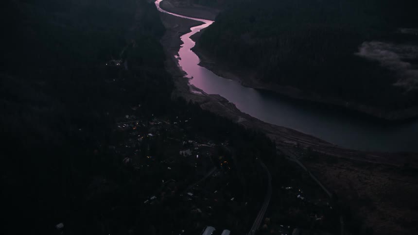 An aerial view of a river that makes large bends in an area near a city