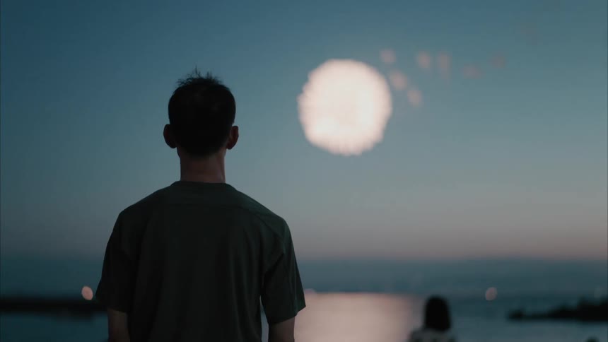 A man watches as the fireworks explode in the sky