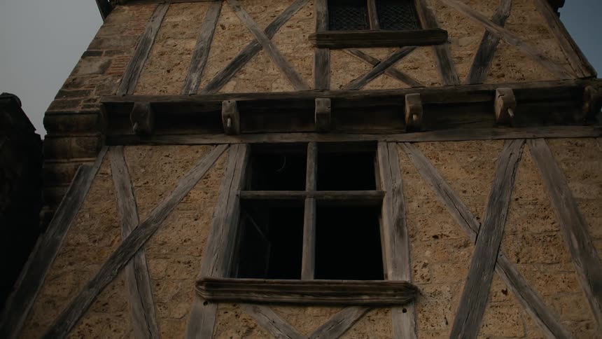 Exterior architecture of a rock structure with wooden windows