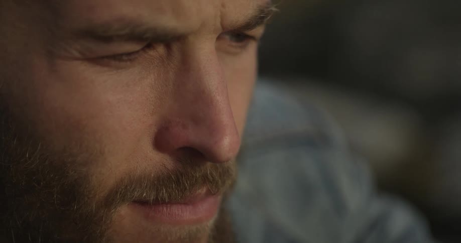 Close-up of a bearded man's face pondering something