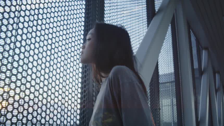 A woman leans forward looking out the building window