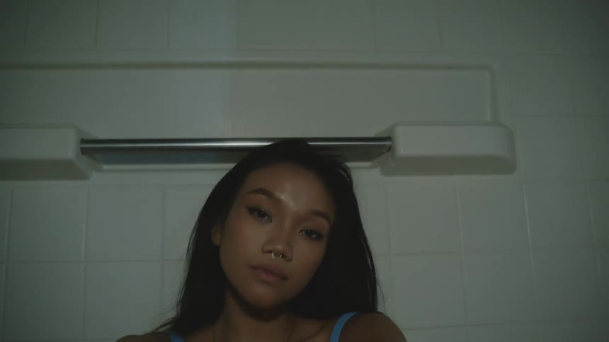 Portrait of a young woman in an indoor space with a white tiled wall